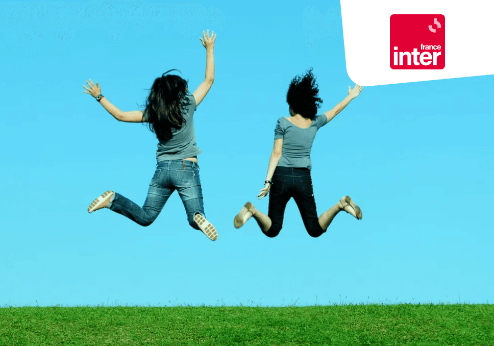 Sur l'image, nous pouvons voir deux adolescentes en train de sauter sur l'herbe. En haut à droite, est positionné le logo de france inter, un carré rouge avec une typographie blanche.