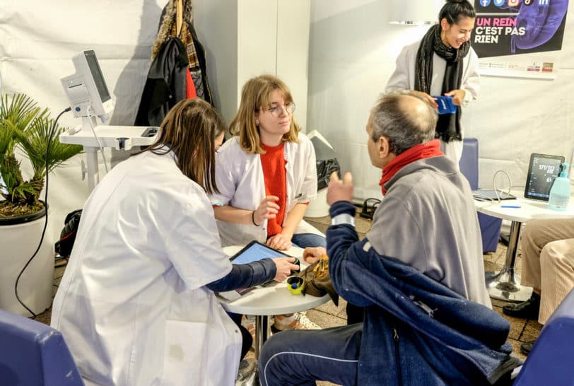 Sur l'image, nous pouvons voir deux infirmières en train de parler à une personne souhaitant se faire dépister. Tous les trois sont assis autour d'une table. Crédit photo : Clinique Saint-Exupéry